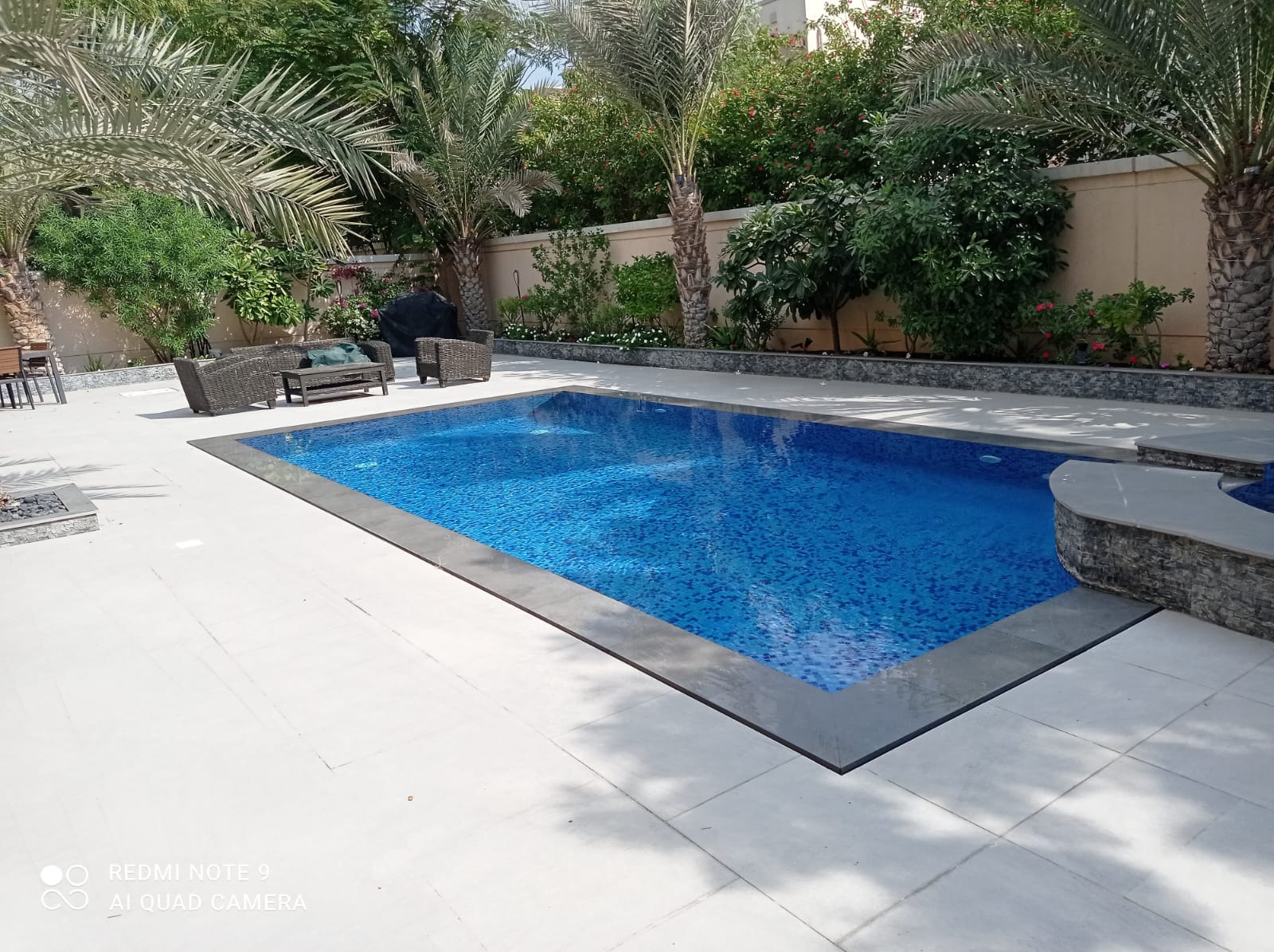 Tiled pool framed by mature palm trees